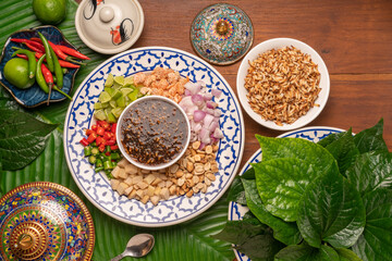 Miang Kham Or wild betel leaves Wrap Ingredients dried shrimps, peanuts, lime, chilli, roasted peanuts with sweet dipping sauce,  Asian appetizer food.