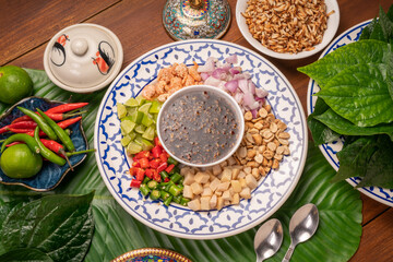 Miang Kham Or wild betel leaves Wrap Ingredients dried shrimps, peanuts, lime, chilli, roasted peanuts with sweet dipping sauce,  Asian appetizer food.