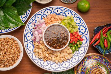 Miang Kham Or wild betel leaves Wrap Ingredients dried shrimps, peanuts, lime, chilli, roasted peanuts with sweet dipping sauce,  Asian appetizer food.
