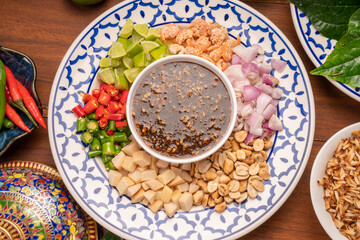 Miang Kham Or wild betel leaves Wrap Ingredients dried shrimps, peanuts, lime, chilli, roasted peanuts with sweet dipping sauce,  Asian appetizer food.