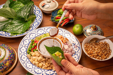 Miang Kham Or wild betel leaves Wrap Ingredients dried shrimps, peanuts, lime, chilli, roasted peanuts with sweet dipping sauce,  Asian appetizer food.