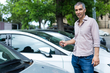 Portrait of man who is standing near his car outdoors.
