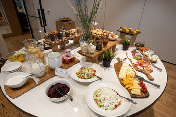 Breakfast served on a round buffet table in a hotel restaurant