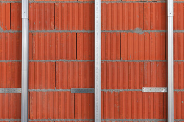 Work in progress on a construction site for a residential building. Brick wall and metal mounting system for the isolation.