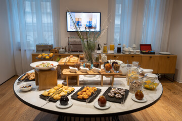 Breakfast served on a round buffet table in a hotel restaurant