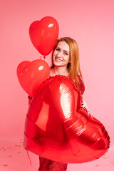 Beautiful redhead girl with red heart baloon posing. Happy Valentine's Day concept