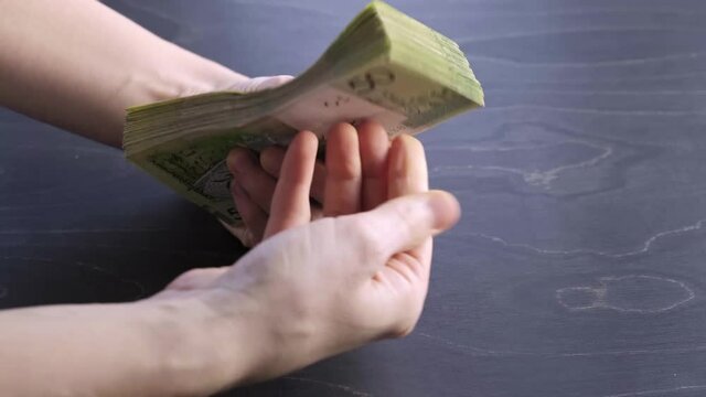 4k. Close-up view of counting stack of belarusian 50 ruble paper money. Hands hold and count a lot of cash. Saving. National currency of Belarus. Credit liabilities. Profit. Big debt. Taxes payment.