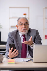 Old male employee sitting in the office