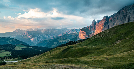 Orange red sunset panorama of Dolomites. Evening view from Sella Pass, Dolomites, Alto Adige, Italy towards Fermeda, Puez-Odle Natural Park.