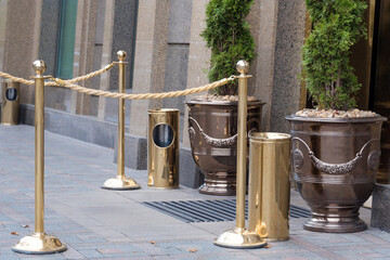 Golden rope barriers near the hotel entrance. Gold pole barricade outdoors.