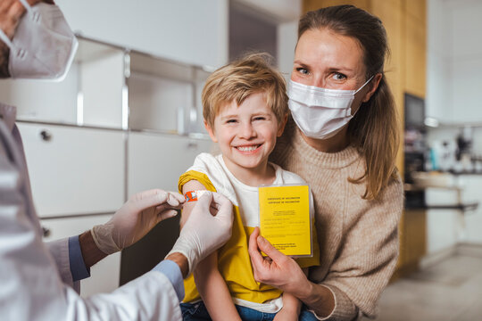 Smiling boy and mother with vaccination certificate at center