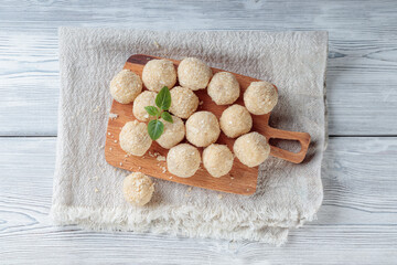 Top view of healthy raw paleo energy coconut balls on white background.