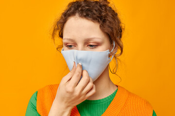 cheerful woman in a yellow t-shirt medical mask protection pink background unaltered