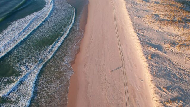 aerial view of waves coming onto shore, sandy beach in the morning, landes france. amazing view of ocean rippling waves