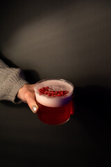 Holding alcoholic cocktail with gin and cranberries