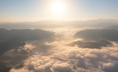 Aerial top view of forest trees and green mountain hills with sea fog, mist and clouds. Nature landscape background, Thailand.