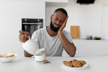 Fototapeta na wymiar Black man pouring coffee away from cup spilling hot drink