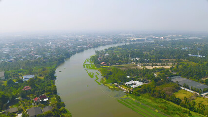 Fototapeta premium Aerial top view of curve of Chao Phraya River and forest trees and green mountain hills. Nature landscape background, Thailand.