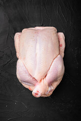 Whole chicken, on black dark stone table background, top view flat lay, with copy space for text