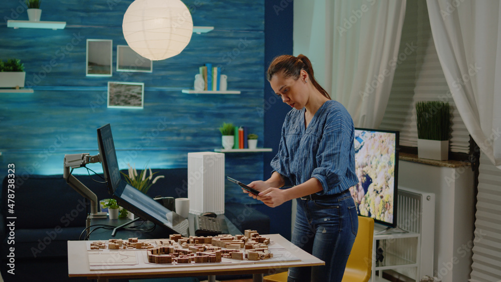  architectural manager checking building model on tablet and computer in office. architect using tech