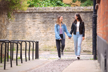 Obraz premium Same Sex Female Couple Sightseeing As They Hold Hands And Walk Around Oxford UK