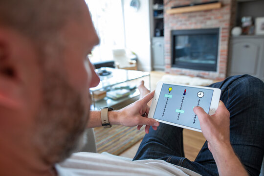 Man controlling home utilities on digital tablet