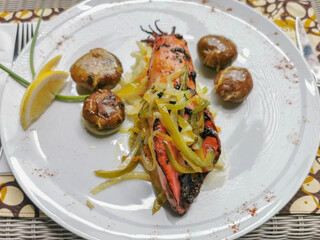 Healthy grilled cuttlefish dish stuffed with vegetables, green peppers and onion, baked potato and lemon slice