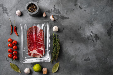 Italian dry cured ham vacuum pack, on gray stone table background, top view flat lay, with copy...