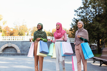Group Of Muslim Women Doing Shopping Walking Carrying Bags Outdoors