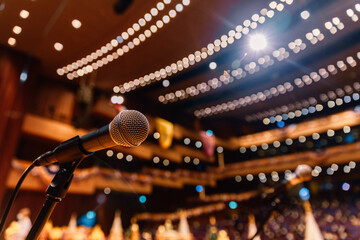 Close up of microphone on the theater stage in concert hall and blurred lights background