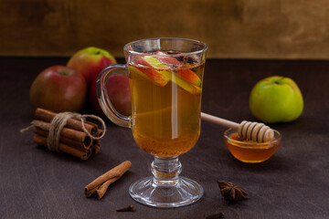 homemade apple cider with fresh apples and honey. Hot fruit tea with spices:cinnamon, cardamon, anise, clove on the wooden table. Christmas drinks with sackcloth. cope space.mulled wine