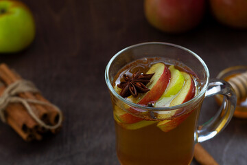 close-up apple cider with cinnamon and honey. Hot fruit tea with spices: cinnamon, cardamon, anise on the wooden table. Christmas drinks with sackcloth.top view. mulled wine