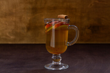 homemade apple cider with apple and honey. Hot fruit tea with spices: cinnamon, cardamon, anise on the wooden table. Christmas drinks.mulled wine with copy space