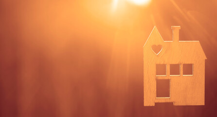 wooden house model against sunset light for sale or rent, family home and shelter concept, real...