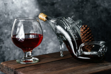 A glass of cognac on a dark background. Cognac on a wooden background. Alcohol on a wooden table. French cognac.