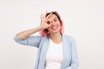 Ambitious corporate woman shows a "good" sign while standing contentedly on a white background