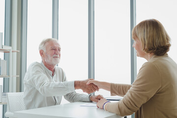 The senior elderly people sitting and handshake for contract agreement.