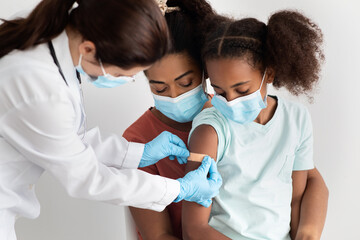 African american family making vaccination at hospital, wearing face masks