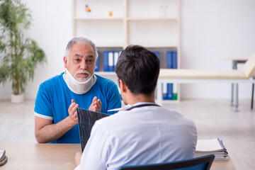 Obraz premium Old male patient visiting young male doctor radiologist