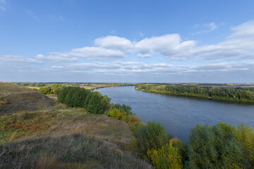 Obraz premium Autumn landscape with a view of the river and endless expanses of fields. Panoramic landscape with river and field and trees.