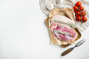Raw duck breast , with herbs and ingredients, on wooden tray, on white stone  background, top view...