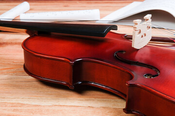 Violin and music notes on a wooden table.