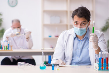 Two male chemists working at the lab during pandemic