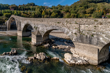 Tree trunks and other debris under the Ponte della Maddalena or del Diavolo bridge, Borgo a...