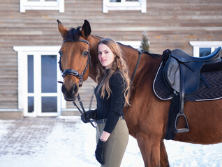 Obraz premium Young girl with horse on winter forest road