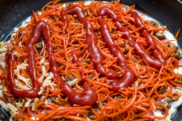 The girl spreads the pizza with slices of cheese.