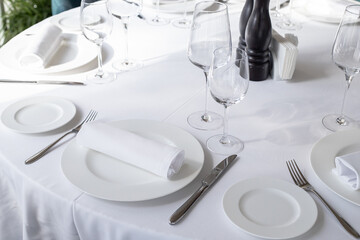 table serving with tablewear glasses and plates in restaurant. selected focus