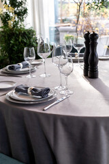 table serving with tablewear glasses and plates in restaurant. selected focus