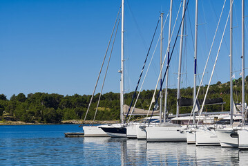 Obraz premium Yachts boats at harbor. Sailing yachts in marina. Sea coast pier. High class lifestyle. Yachting. Croatia, mediterranean marina