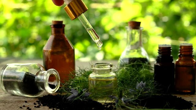 Black cumin oil in a bottle. Selective focus.
